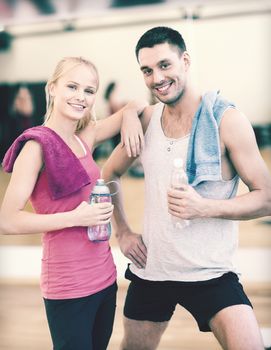 fitness, sport, training, gym and lifestyle concept - two smiling people in the gym