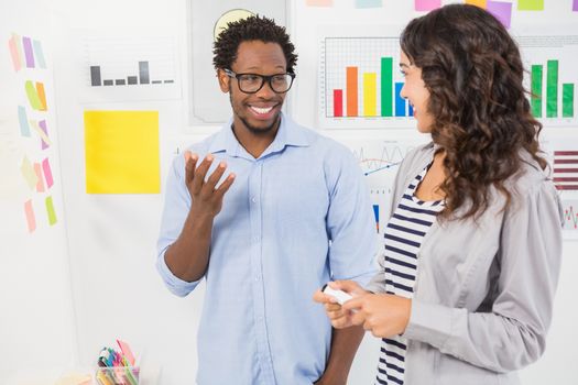 Young smiling creative business people at the office looking and talking to each other