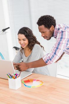 Young business people looking at a laptop in the office