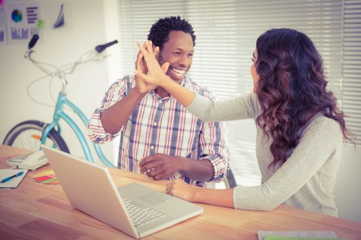 Young business people smiling at each other in the office