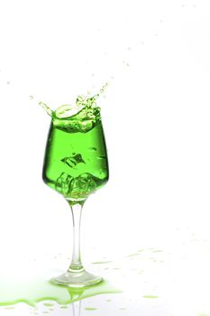 Stemmed champagne glass with liquor splashing out, isolated on white background