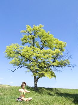 women meditate under tree