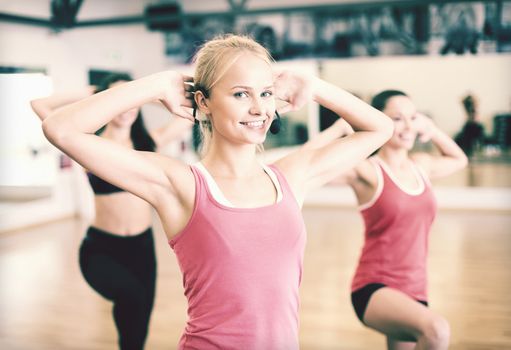 fitness, sport, training, gym and lifestyle concept - group of smiling people with trainer exercising in the gym