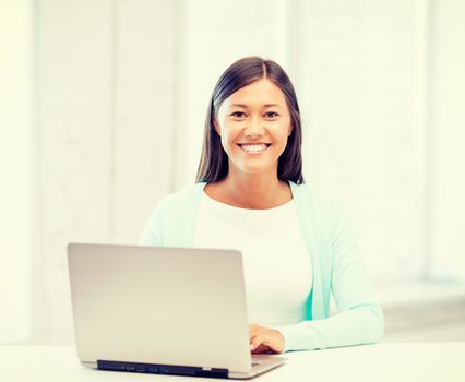 education concept - smiling international student girl with laptop at school