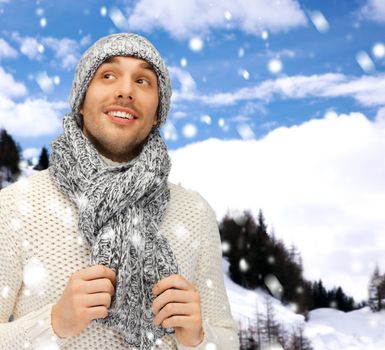 winter holidays, vacation and lifestyle concept - handsome man in warm sweater, hat and scarf