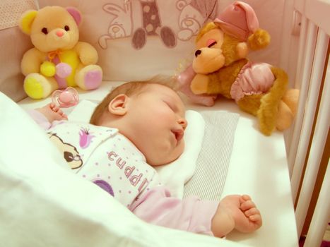 Newborn baby sleeping with toys vintage photo