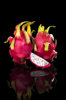 Two dragon fruits isolated on black background. Tropical fruit, luxurious minimal style. 