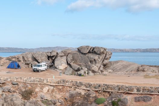 LUDERITZ, NAMIBIA - JUNE 15, 2011: Camping site nr 27 on Shark Island, in the coastal town of Luderitz. This is the only spot on the island that offers shelter to the cold sea wind