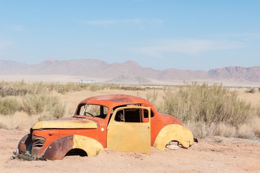 SOLITAIRE, NAMIBIA - JUNE 22, 2012: An old vehicle next to the road at Solitaire, a small village near Sossusvlei