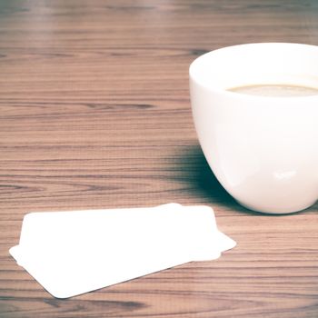 coffee cup and business card on wood background vintage style