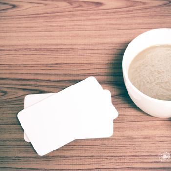 coffee cup and business card on wood background vintage style