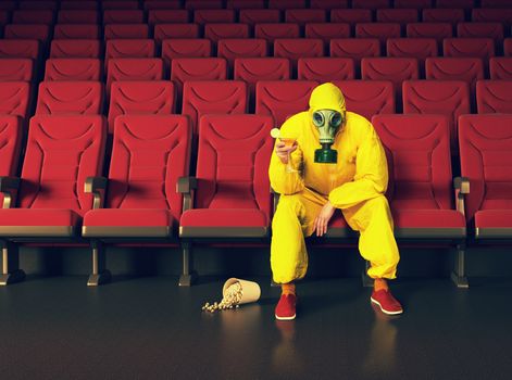 the man in a protective coverall  sitting in an empty theater. Creative concept