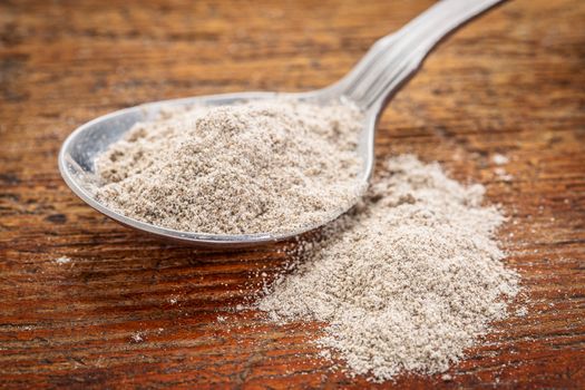 tablespoon of gluten free buckwheat flour against rustic wood