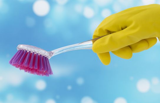 Yellow Gloved hand holding a cleaning brush