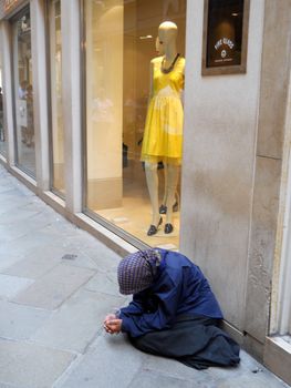 beggar woman in front of lux store







beggar