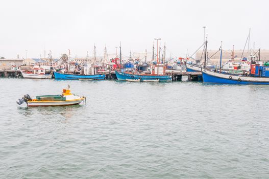 LUDERITZ, NAMIBIA - JUNE 14, 2011: Fishing boats at the harbor in Luderitz on a gloomy day. The small town is known for its crayfish inustry