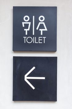 Unisex restroom or Toilet and arrow sign on concrete wall style boutique