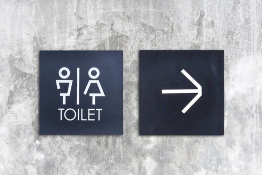 Unisex restroom or Toilet and arrow sign on concrete wall style boutique