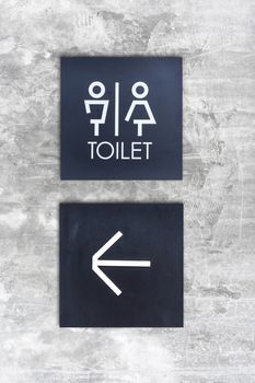 Unisex restroom or Toilet and arrow sign on concrete wall style boutique