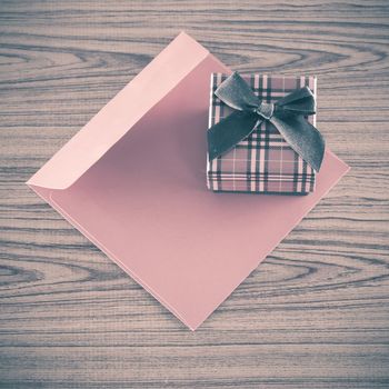 red gift box and envelope on wood background