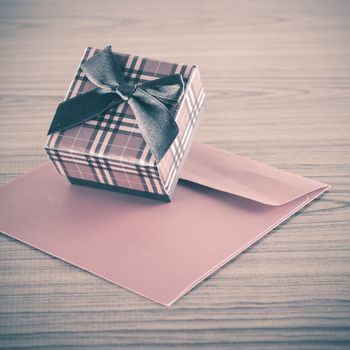 red gift box and envelope on wood background