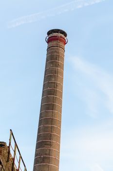 View of an old brick chimney of an abandoned factory.
