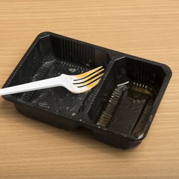 dirty plastic food container on wood background