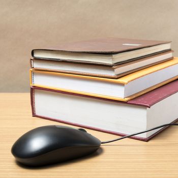 book and computer mouse on wood background