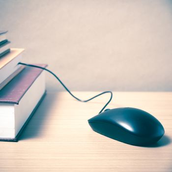 book and computer mouse on wood background vintage style