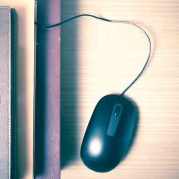 book and computer mouse on wood background vintage style