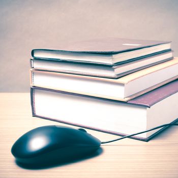 book and computer mouse on wood background vintage style