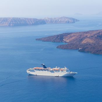 Luxury cruise ship sailing around Santorini island, Aegean sea in Greece.