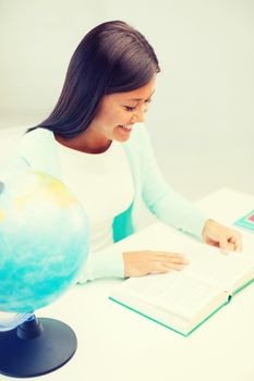 education and school, travel concept - female teacher with globe and book