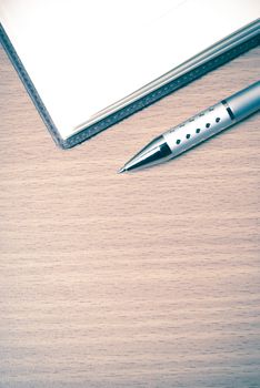 book and pen on wood background vintage style