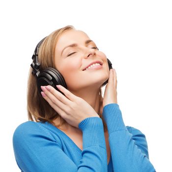 music and technology concept - smiling young woman with closed eyes listeting to music with headphones