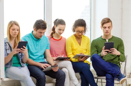 education and technology concept - smiling students with tablet pc computer at school