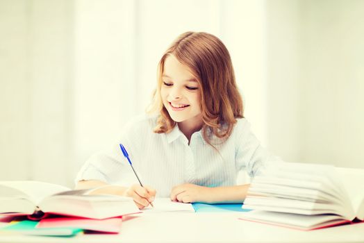 education and school concept - little student girl studying at school