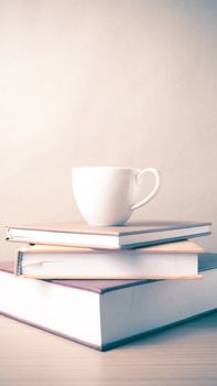 stack of book with coffee cup on wood table background vintage style