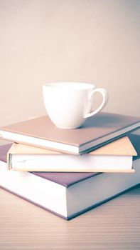 stack of book with coffee cup on wood table background vintage style