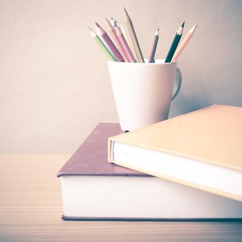 stack of book with color pencil on wood table background vintage style