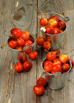 Ripe Sweet Maraschino Cherries in Tin Buckets closeup Rustic Wooden background
