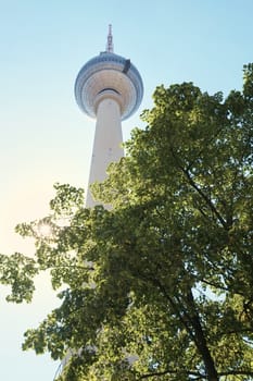 BERLIN, GERMANY - JULY 07: Low angle shot of TV tower in Alexanderplatz, with tree branches in the foreground. July 07, 2015 in Berlin.