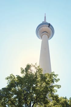 BERLIN, GERMANY - JULY 07: Low angle shot of TV tower in Alexanderplatz, with tree branches in the foreground. July 07, 2015 in Berlin.