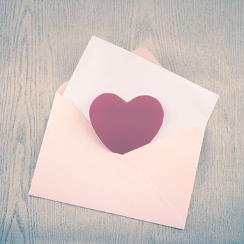 red heart with pink envelope on wooden background vintage style