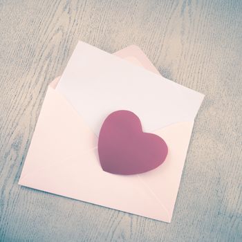 red heart with pink envelope on wooden background vintage style