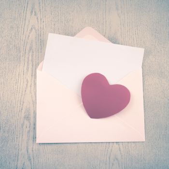 red heart with pink envelope on wooden background vintage style