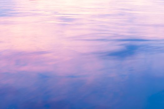 Abstract background. light on water as colors of clouds at sunset reflect.