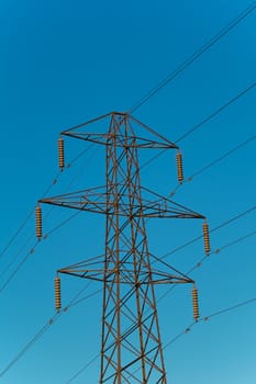 electricity pylon with six arms against a blue sky