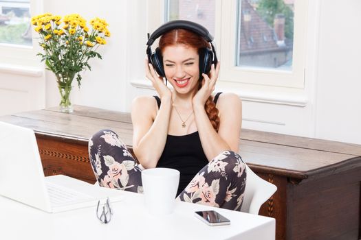 Happy Young Pretty Woman Laughing While Listening Funny Music Using Headphone Inside her Room.