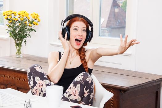 Happy Young Pretty Woman Laughing While Listening Funny Music Using Headphone Inside her Room.